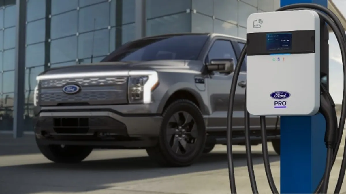 A Ford truck sits behind a Ford Pro EV charging station