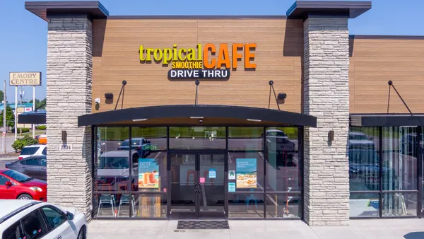 A daytime image of a building with beige bricks and a Tropical Smoothie Cafe sign.