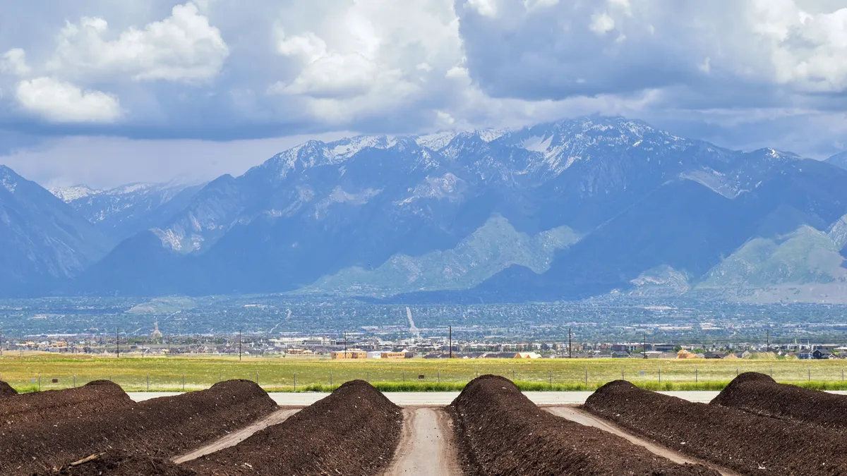 Rows of compost ready for sale with panoramic view of Wasatch Front Rocky Mountains, Great Salt Lake Valley in Utah.