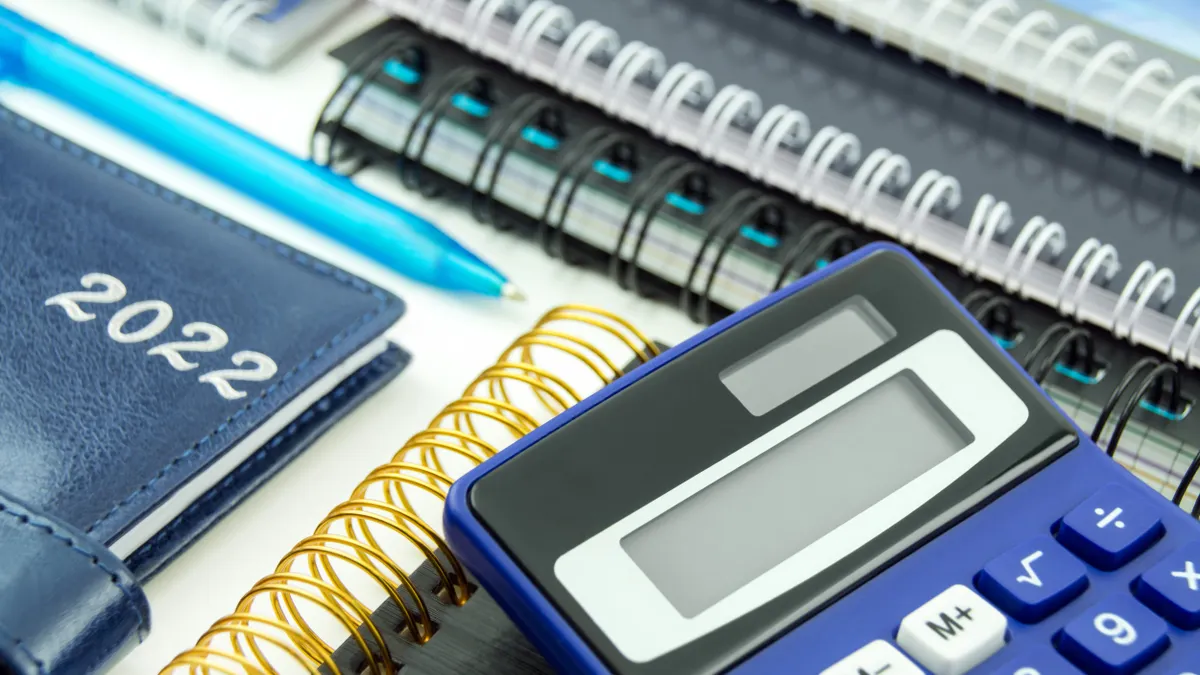 Finances with blue calculator and calendar 2022