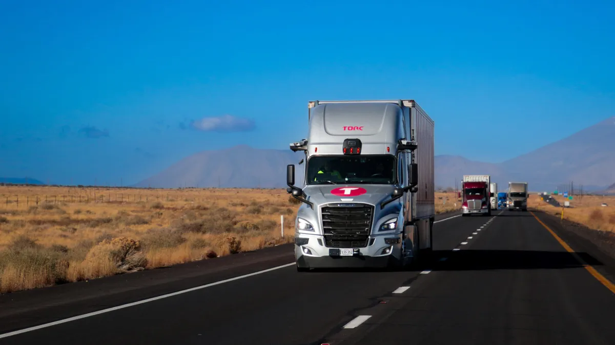 A Torc Robotics truck on a highway with other trucks in the background.