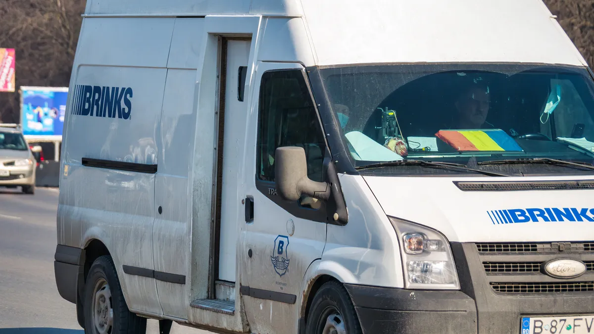 Van in traffic with the Brink's Company logo. Brink's Company is an American private security and protection company