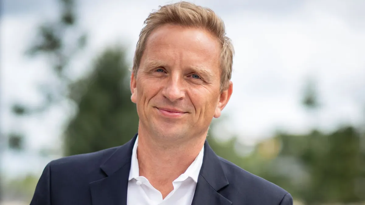 Elekta CEO Jakob Just-Bomholt is pictured in an open-collar white shirt and Navy blue blazer.