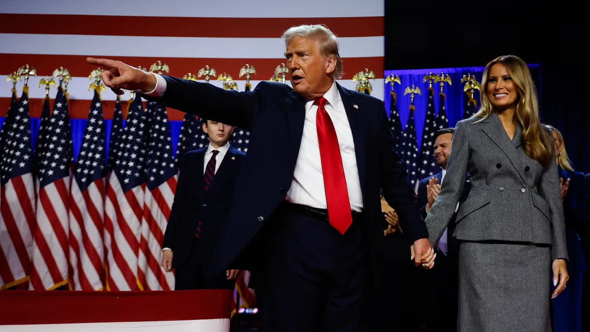 Republican presidential nominee, former U.S. President Donald Trump points to supporters with former first lady Melania Trump during an election night event at the Palm Beach Convention Center on November 06, 2024