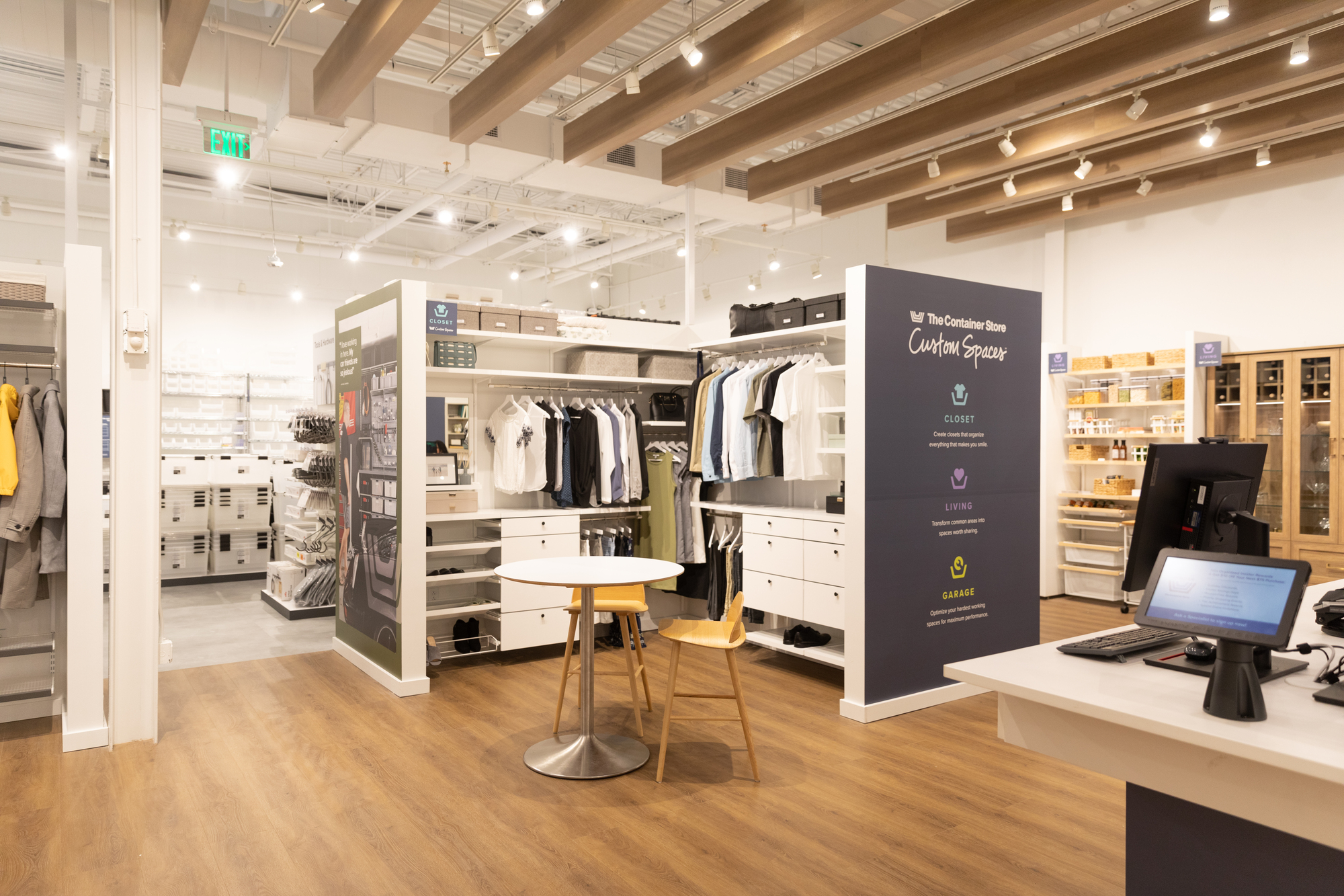 An organized closet display featuring The Container Store's "Custom Spaces" branding.