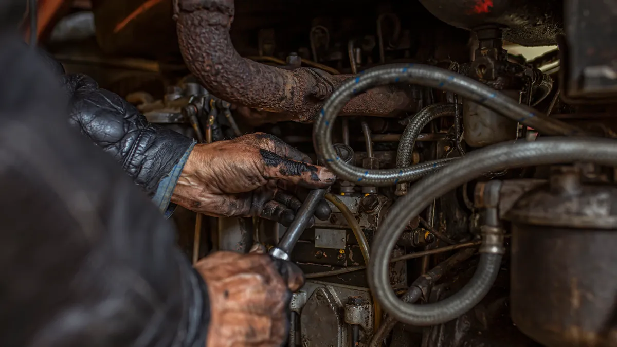 A close-up of a technician's hands during truck maintenance.