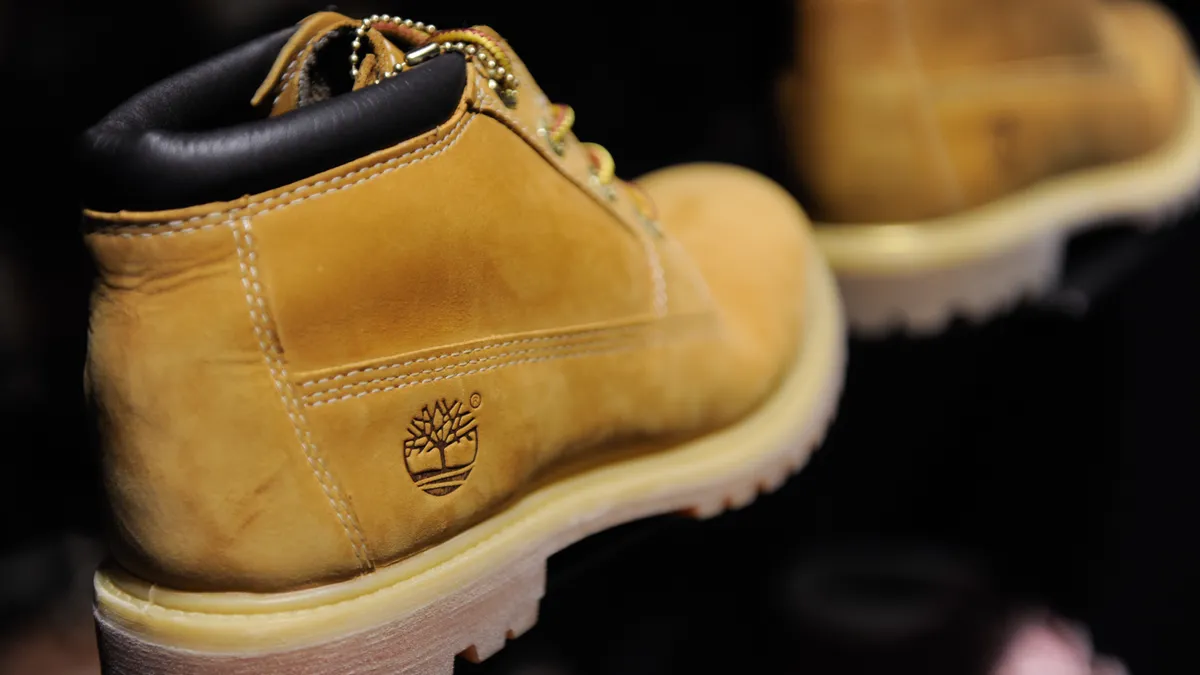 A Timberland boot is shown on a store display, focused on the logo on its heel.