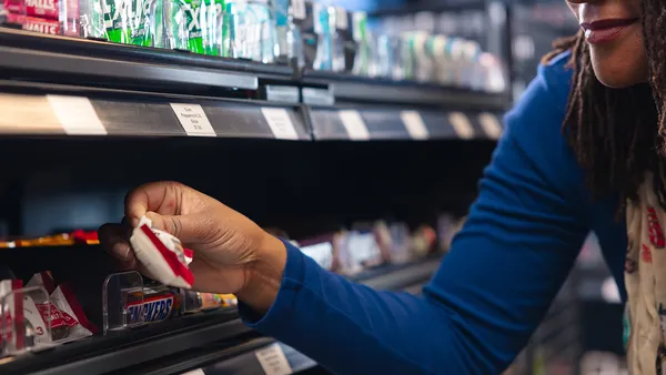 Woman picking up snacks in a grocery store