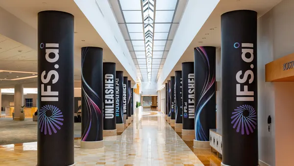 Pillars in a convention center hallway bearing marketing information for the IFS Unleashed technology vendor conference.