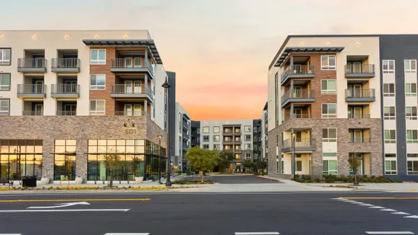 Brown and white mid-rise apartment community.
