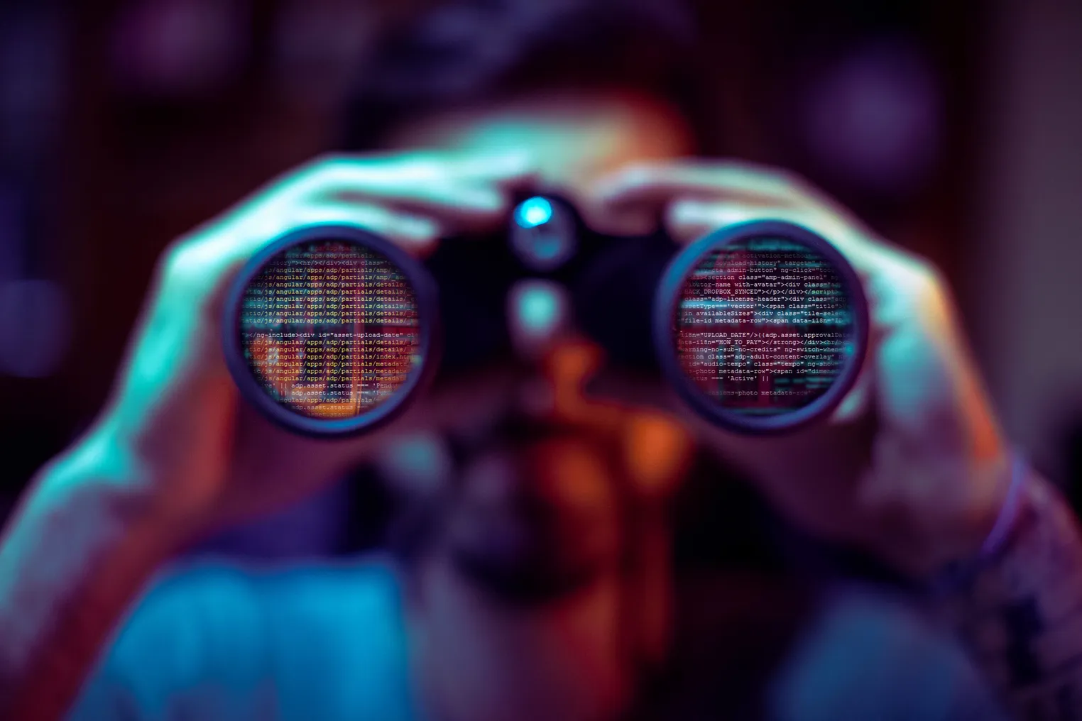 A pair of binoculars covered with code, indicating a cybersecurity breach