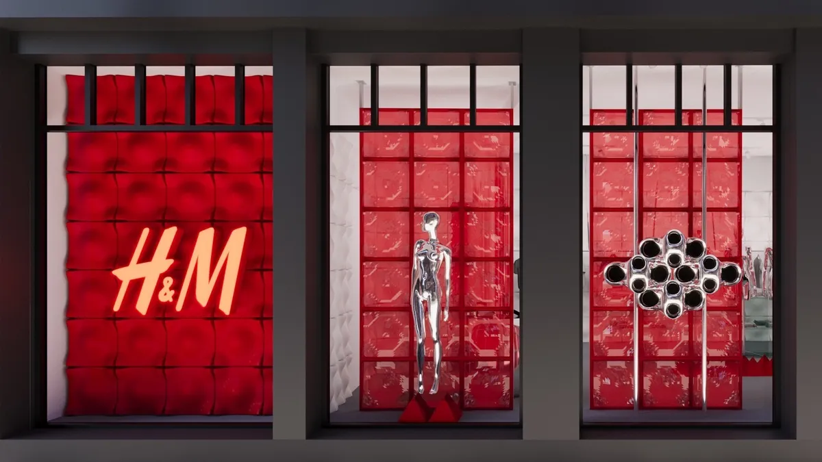 The exterior of H&M's pop-up in New York City's Nolita neighborhood. There are metallic silver mannequins in the window with a red background.