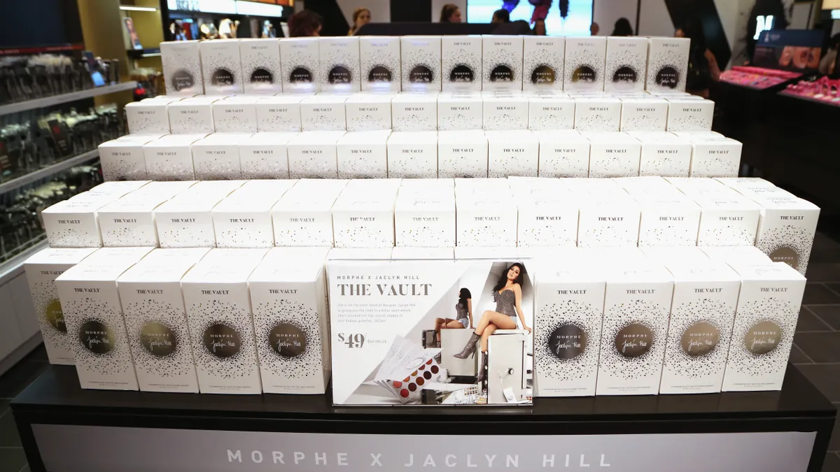 Stacked white boxes of makeup on a black store display