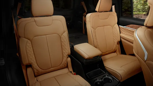 The second-row seats in a 2024 Jeep Grand Cherokee L with the optional tan Summit Reserve interior color scheme.