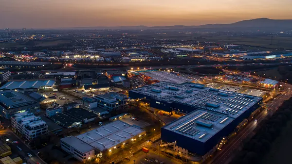 Birds eye view of a city or town at sunset with lights on.