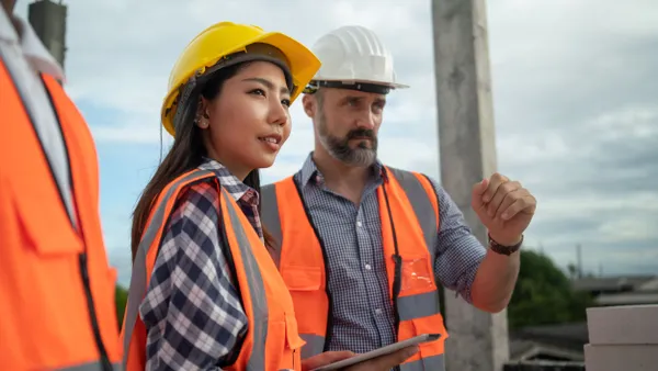 Two construction workers wearing safety hats.