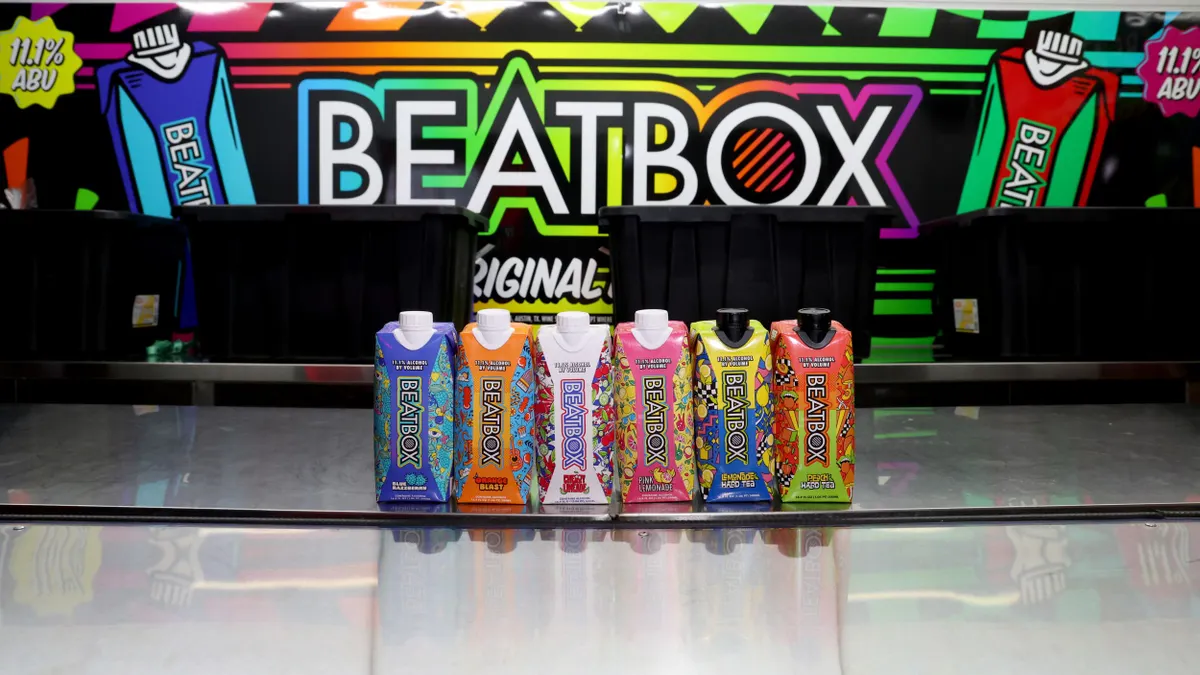 Beatbox cartons are lined up in front of a colorful sign displaying the Beatbox logo.