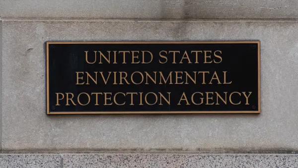 Metal sign that says Environmental Protection Agency on stone wall of building.