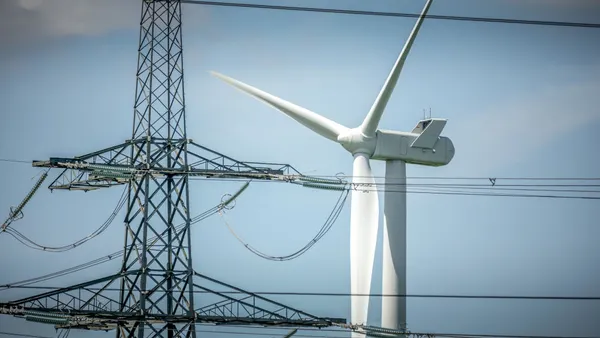 Wind turbines generate power and pylons carry electricity near the Keadby Power Station on July 29, 2024 in Scunthorpe, England.