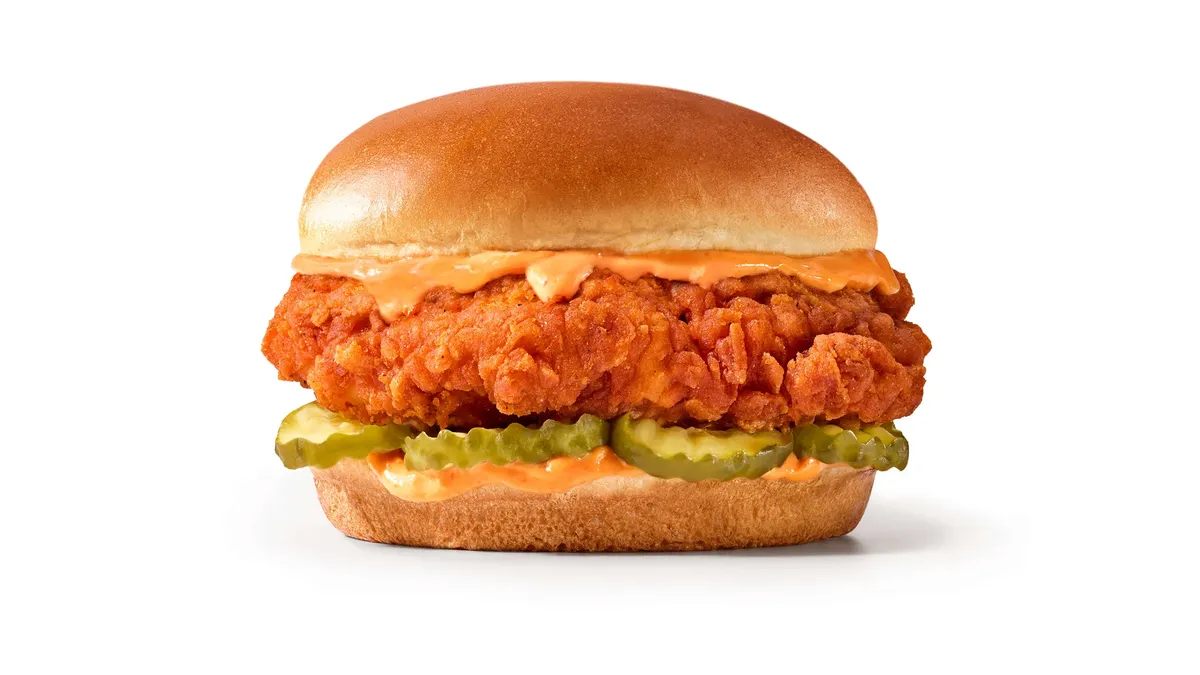 A photo of a breaded chicken sandwich on a white background.