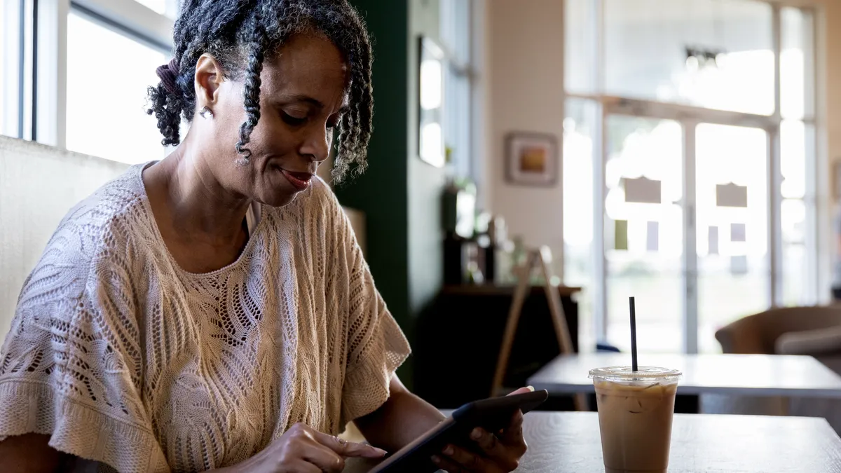 A woman using a tablet in a cafe.