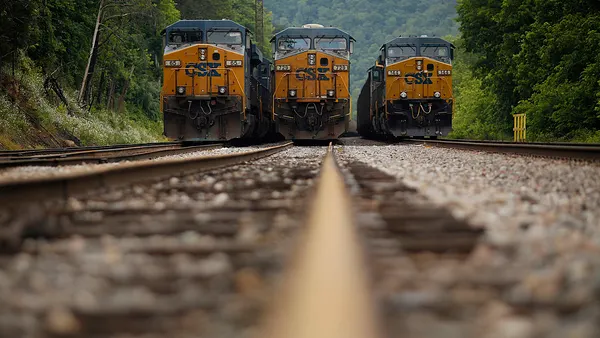 A cargo train with the CSX logo on a rail yard.