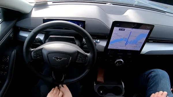 An interior view of a Mustang Mach showing the hands of the front seat occupants