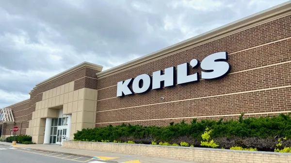 Dark clouds over a store entrance. A brick-red exterior wall with a "Kohl's" sign.