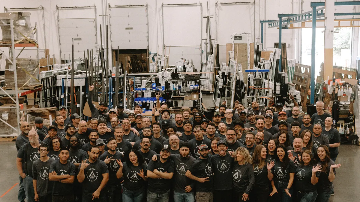 A large group of people in Awake Window & Door's manufacturing facility