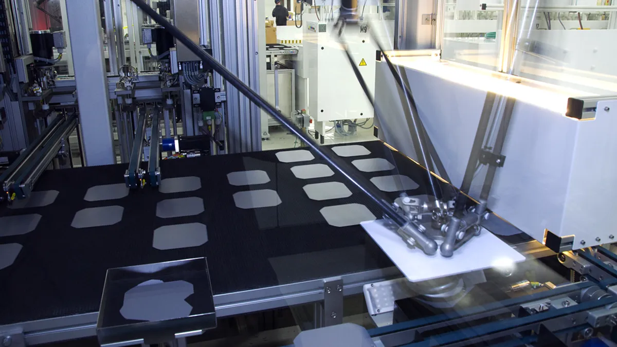 Solar wafers being checked for quality by a machine in U.S. manufacturing stage