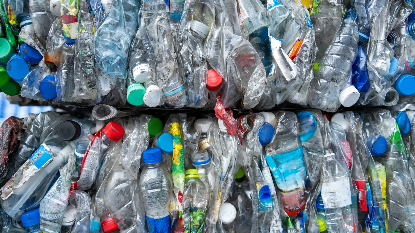 A close up of baled plastic recyclable bottles and containers.