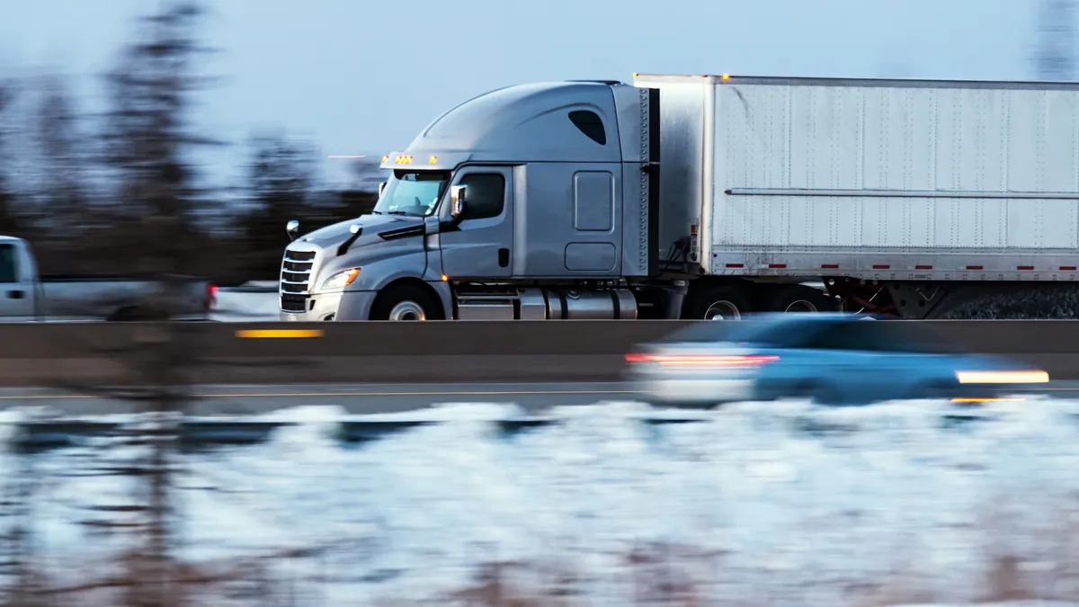 A tractor-trailer travels in the evening light in Canada.