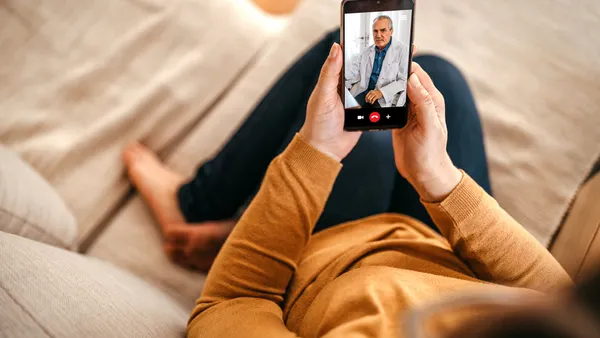 Mature woman having online consultation with doctor at home on smartphone