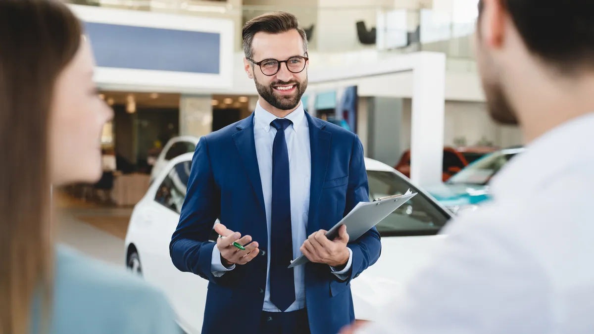 A car salesperson speaking with customers.