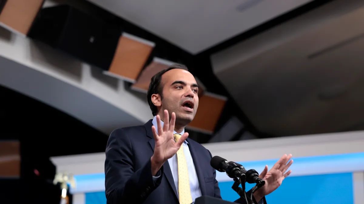 Rohit Chopra, Director of the Consumer Financial Protection Bureau, giving a speech in an auditorium.