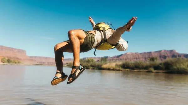 A person doing a backflip wearing Teva sandals