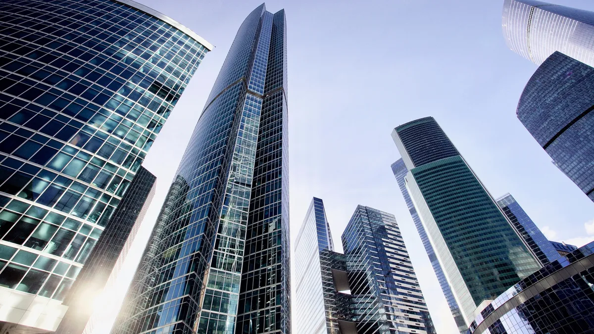 Office and residential skyscrapers against bright sun and clear blue sky.