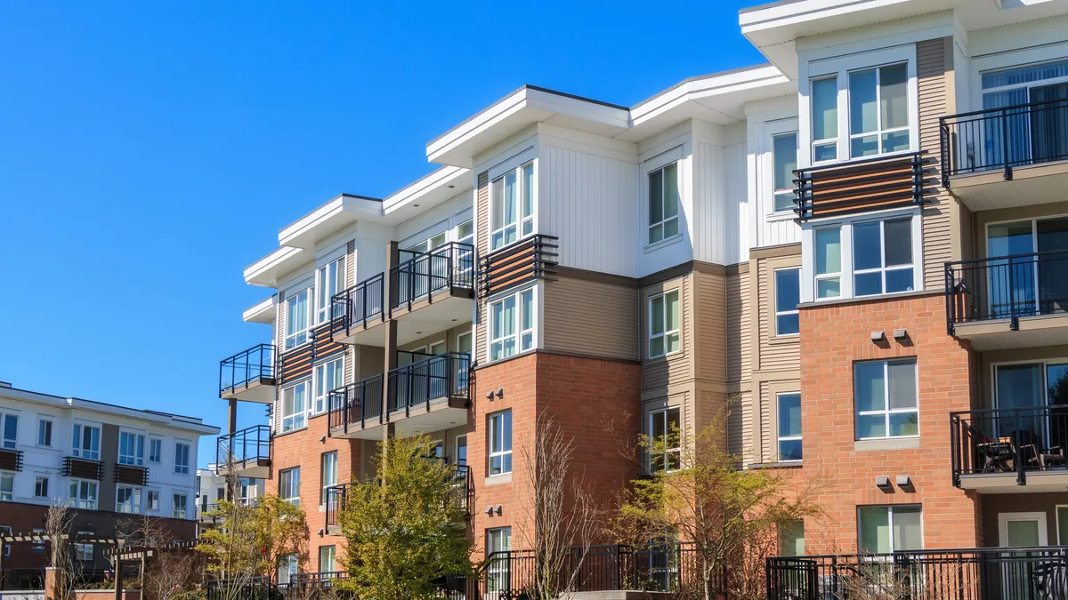 Three-story, multi-colored apartments with balconies.