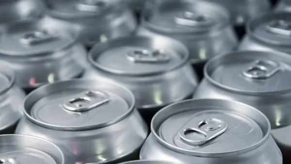 The tops of silver tabbed beverage cans