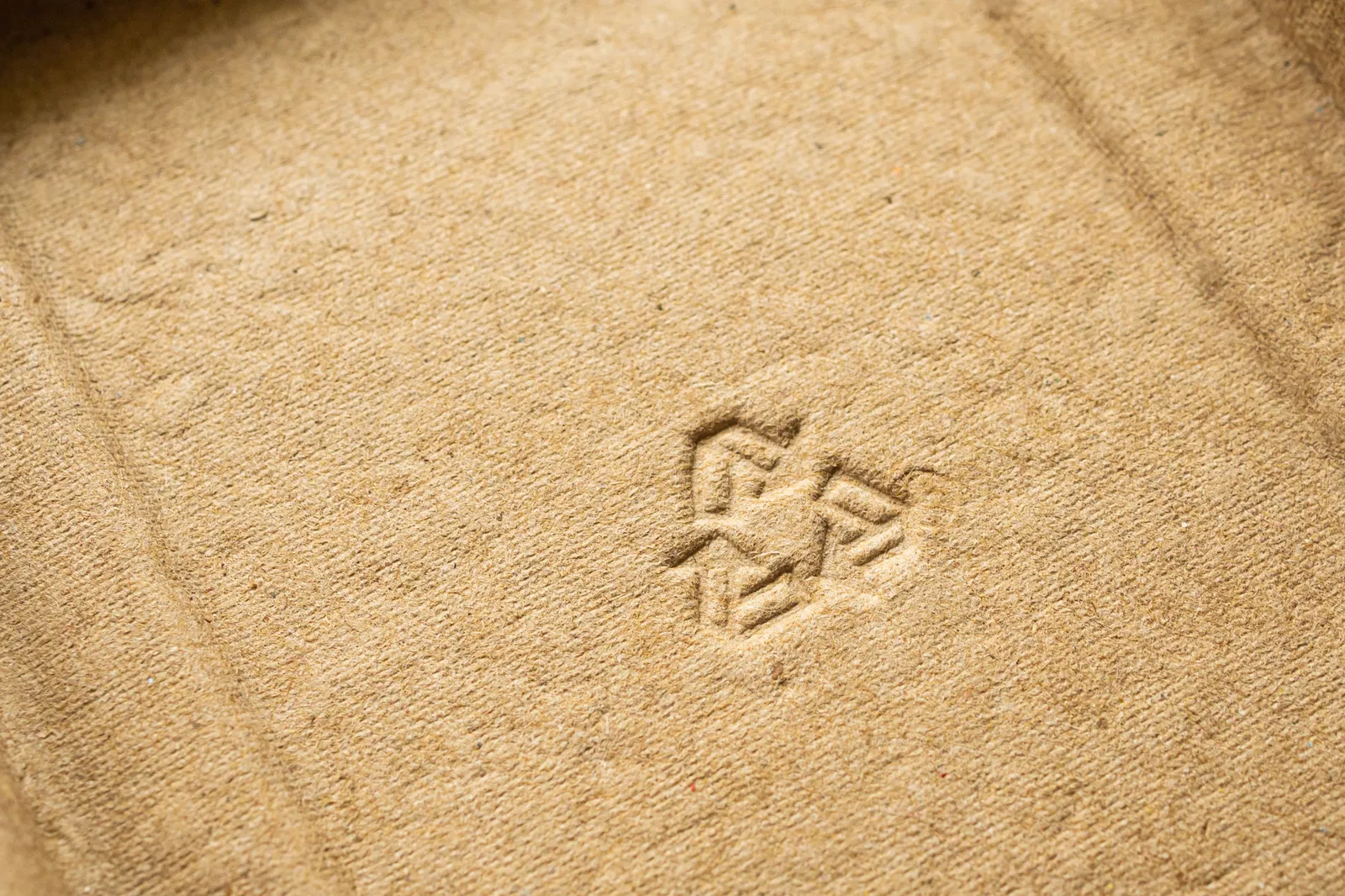 Cardboard with an imprinted chasing arrows recycling symbol.