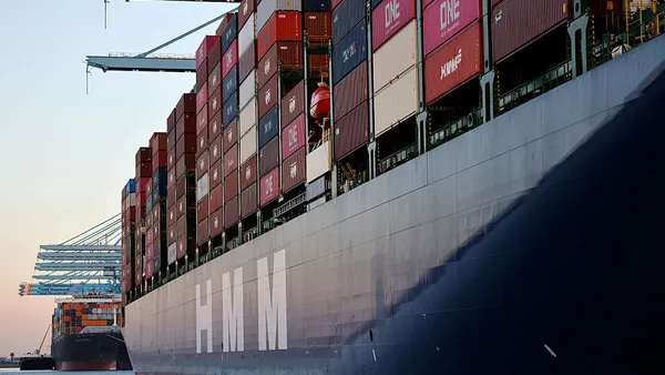 Colorful shipping containers stacked onboard an ocean vessel at a water port.
