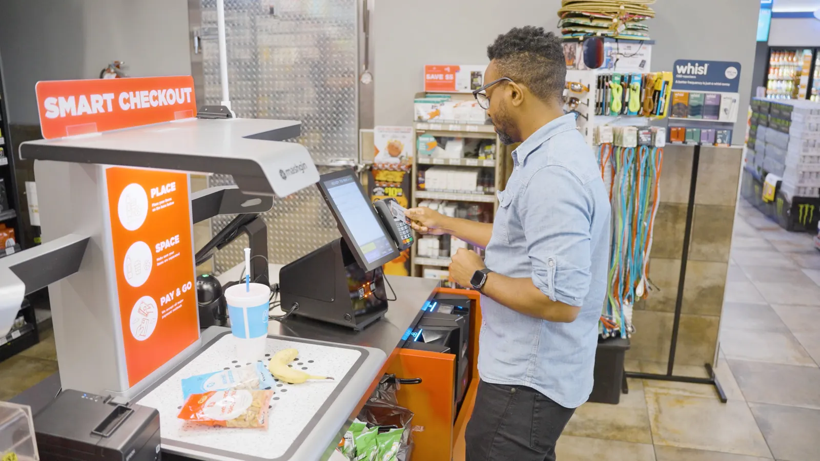 A photo of someone using a Mashgin self-checkout machine.