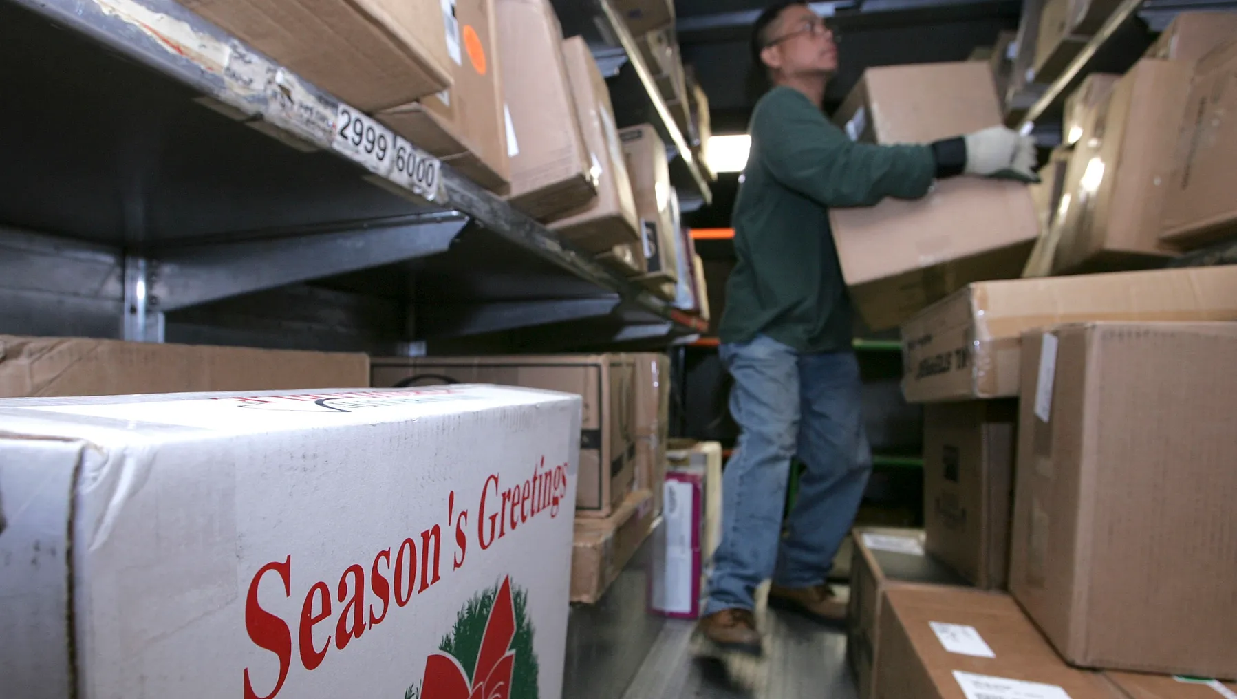 A UPS worker sorts holiday deliveries in a truck.