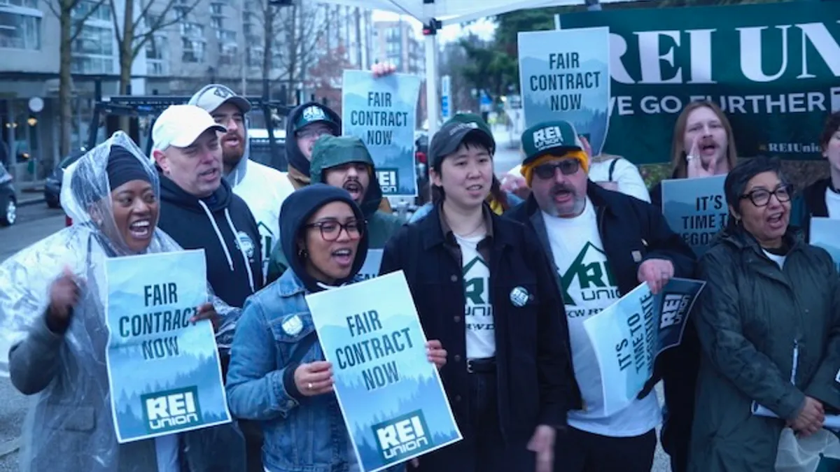 A group of people holding signs that say "Fair contract now."