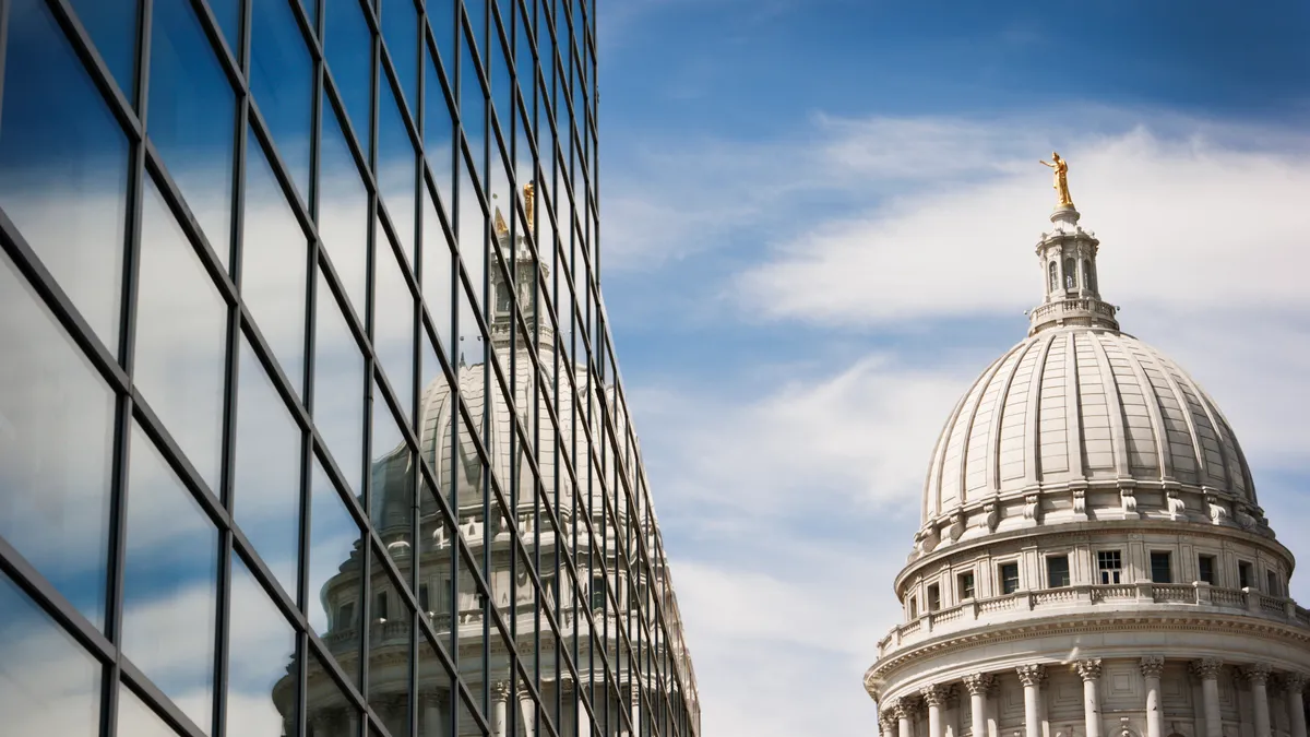 The Wisconsin State Capitol dome reflecting in a steel and glass building