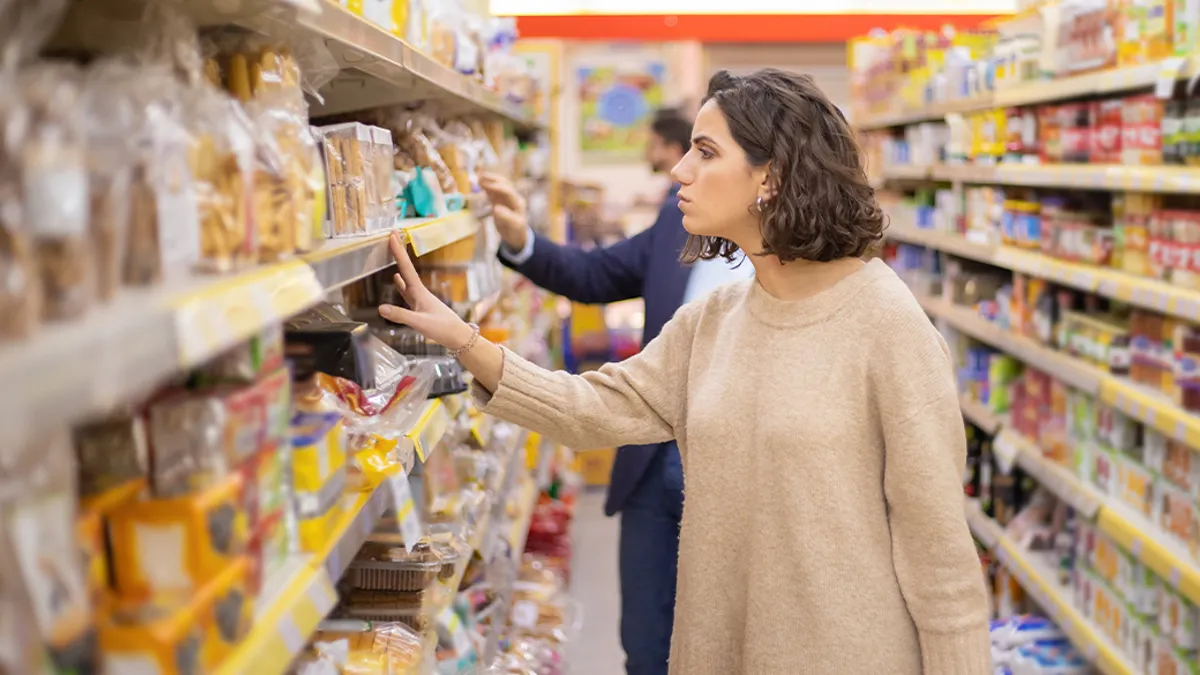 Woman looking at cookies in grocery store.