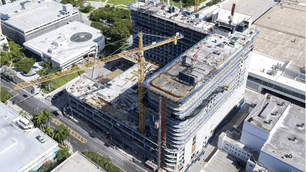 An aerial view of a crane over a large construction project.