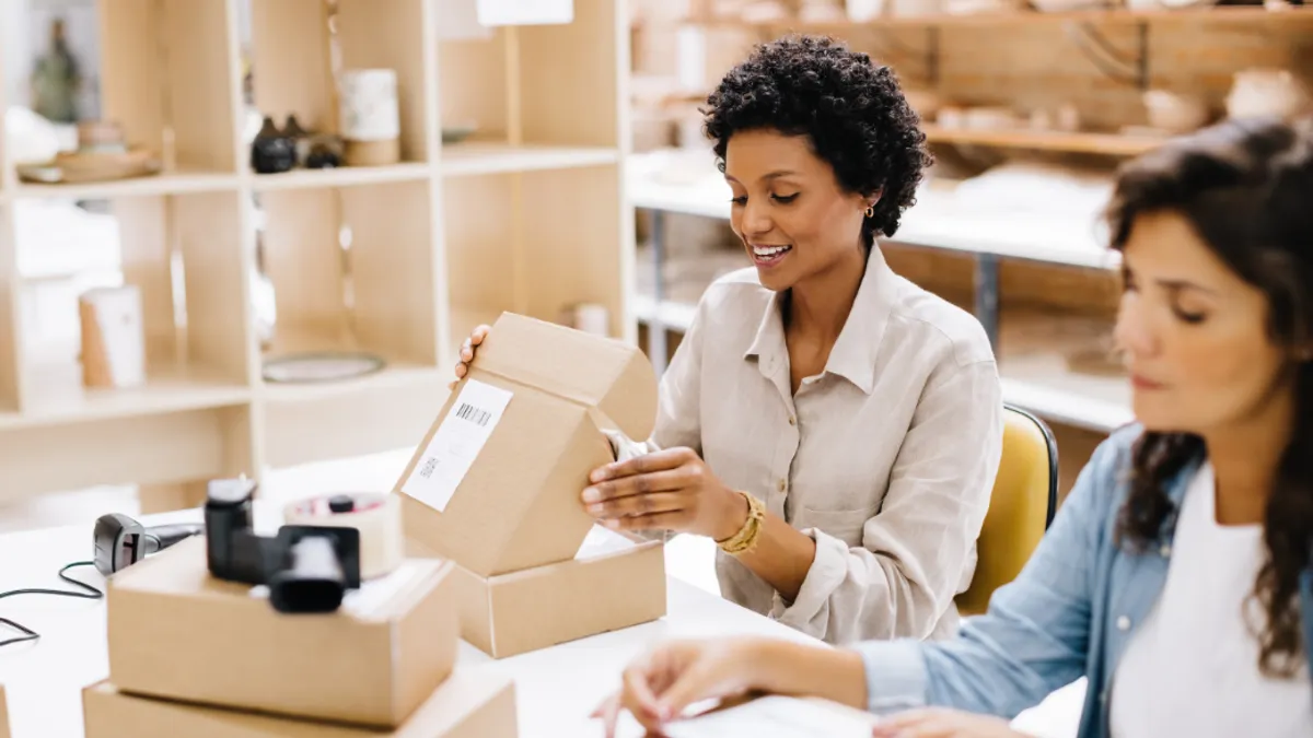 Cheerful online store owner preparing an order for shipping