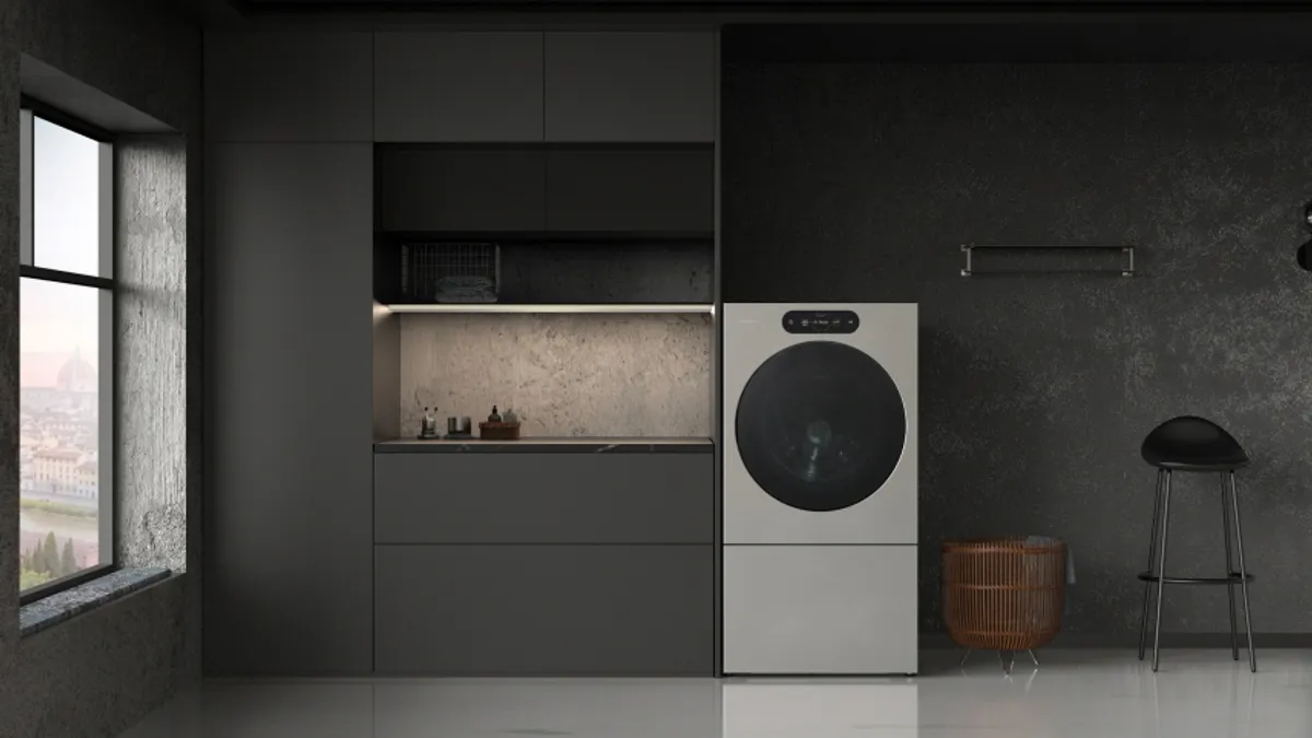 A black-walled laundry room with a washer-dryer in it.