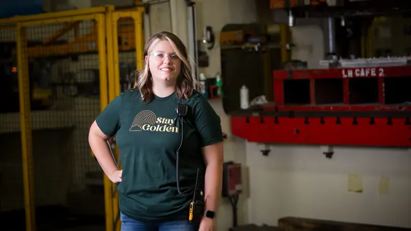 A person wearing a "Stay Golden" t-shirt stands in a GE Appliances facility